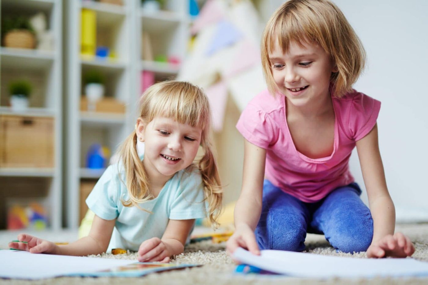 Twee meisjes tekenen samen op de grond